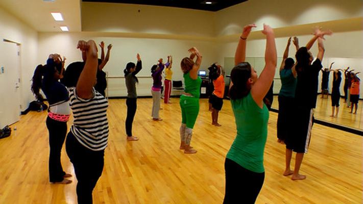 group of dancers reaching upwards in dance studio