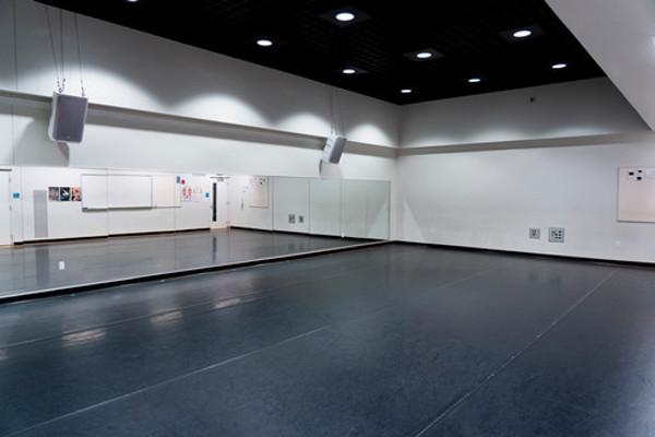 Dance studio 018 with black floor, empty (can see door in mirror)