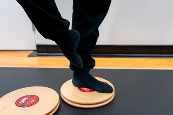 dancer standing on one foot (coup de pied) position on rotating disc